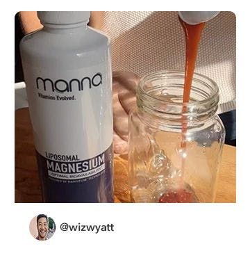 A manna customer holding up a bottle of Liposomal Magnesium 4